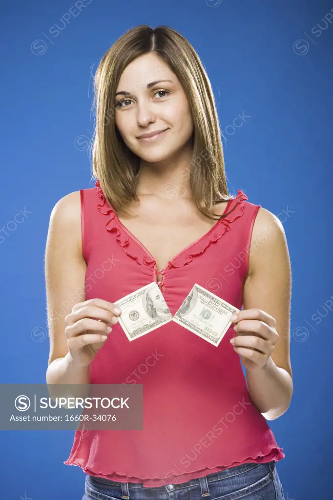 Woman tearing American hundred dollar bill