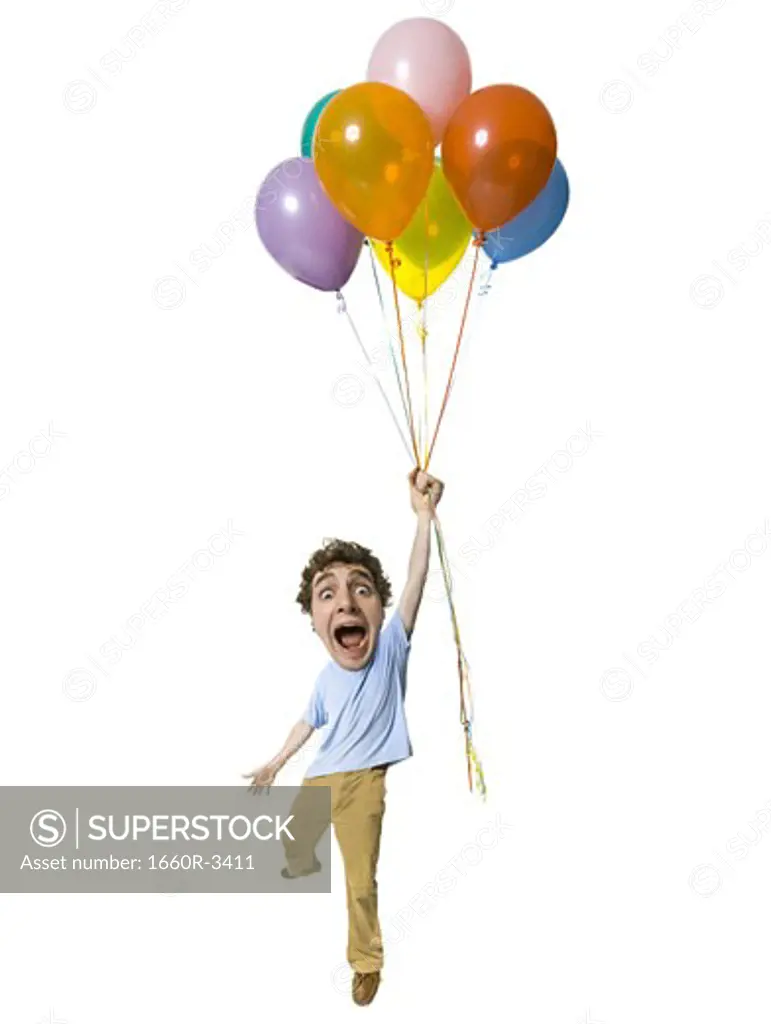 Portrait of a young man holding a bunch of balloons
