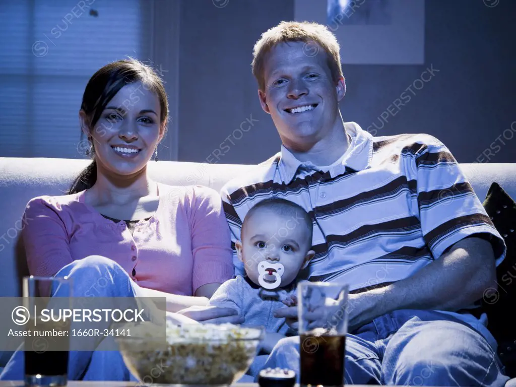 Couple on sofa with baby smiling