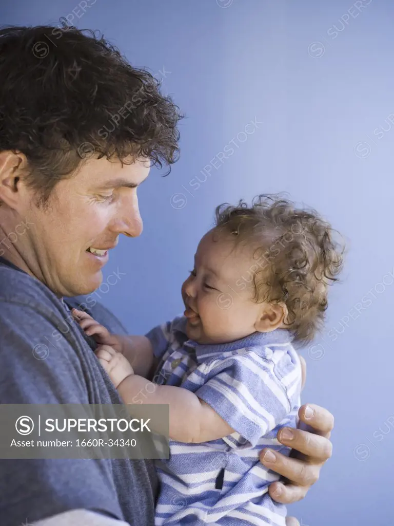 Man holding baby boy smiling