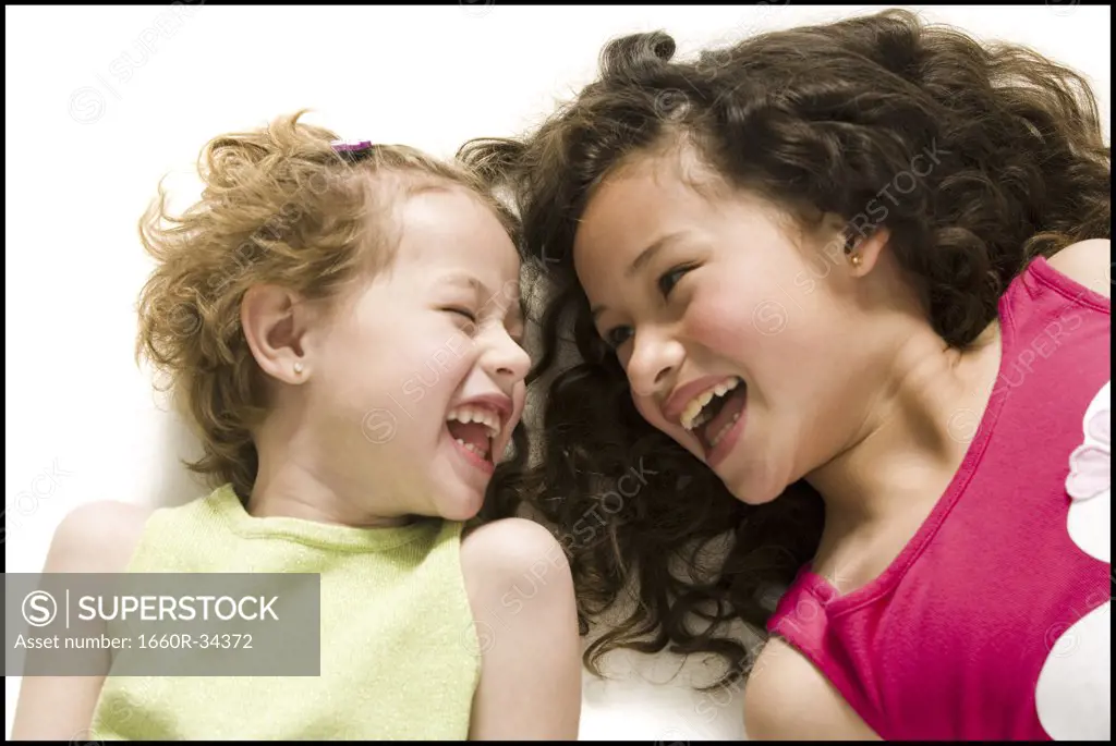Two girls lying down laughing