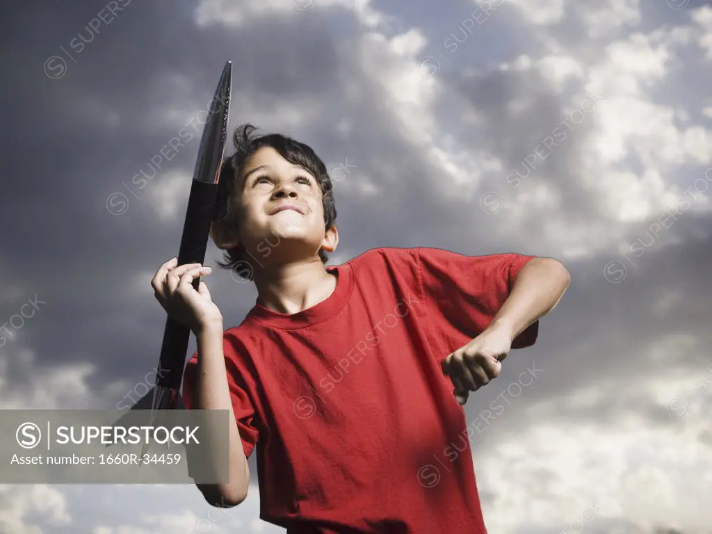 Boy playing with toy rocket outdoors