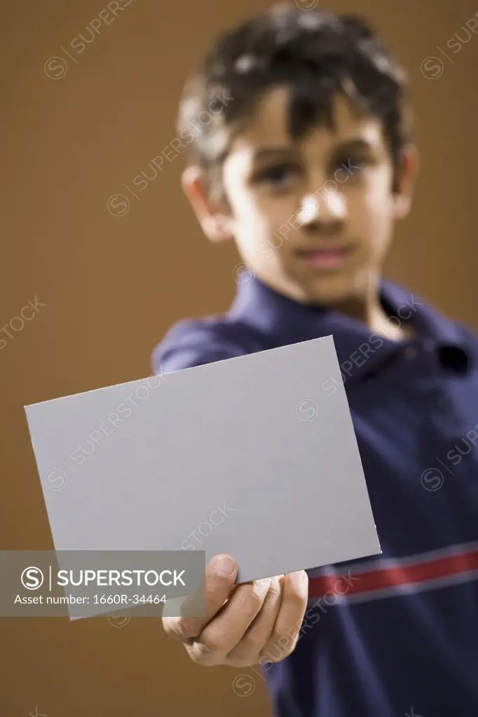Boy holding blank card smiling