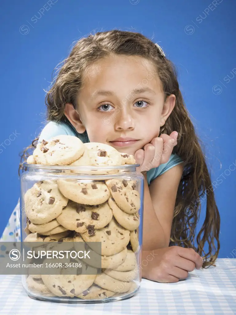 Girl looking at chocolate chip cookies in cookie jar