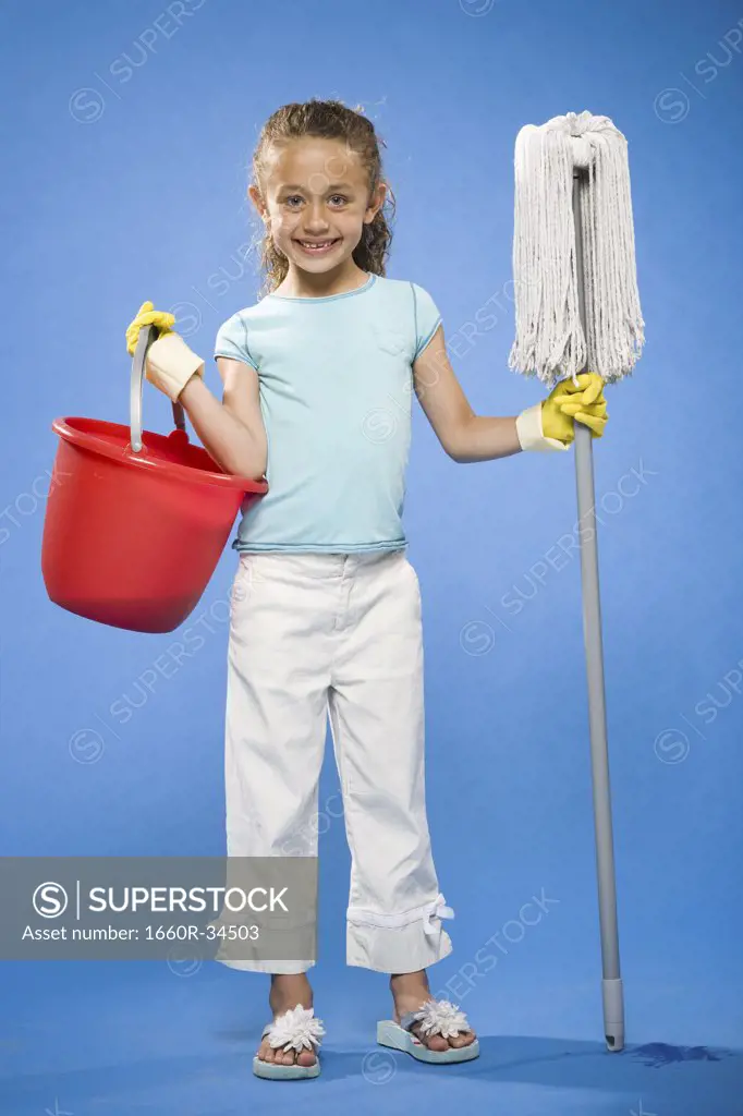 Girl holding mop and bucket with rubber gloves smiling