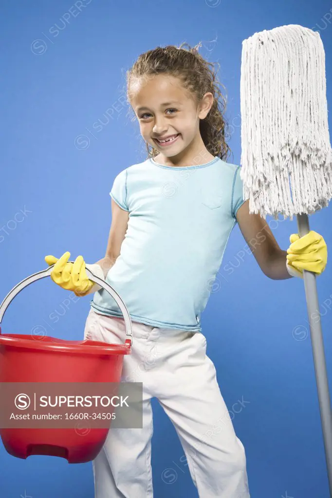 Girl holding mop and bucket with rubber gloves smiling