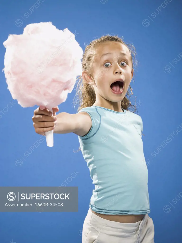 Girl holding cotton candy smiling