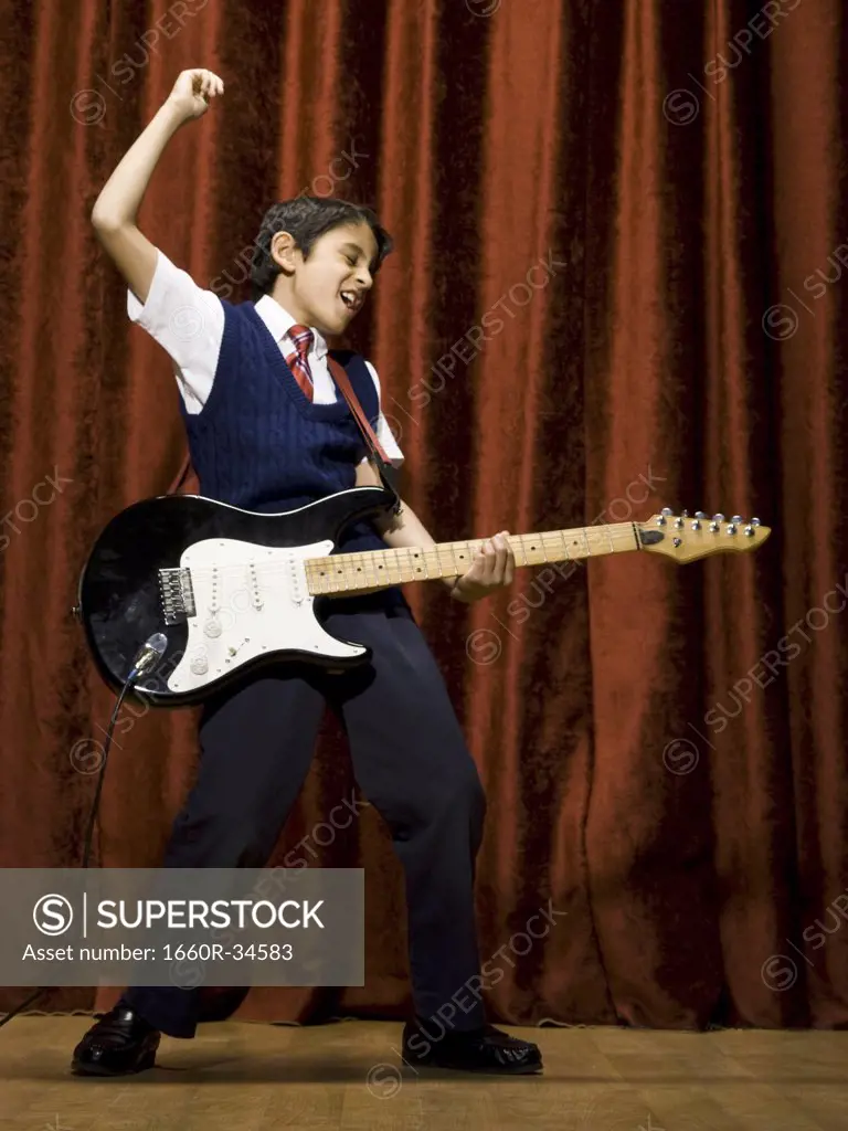 Boy on stage playing electric guitar