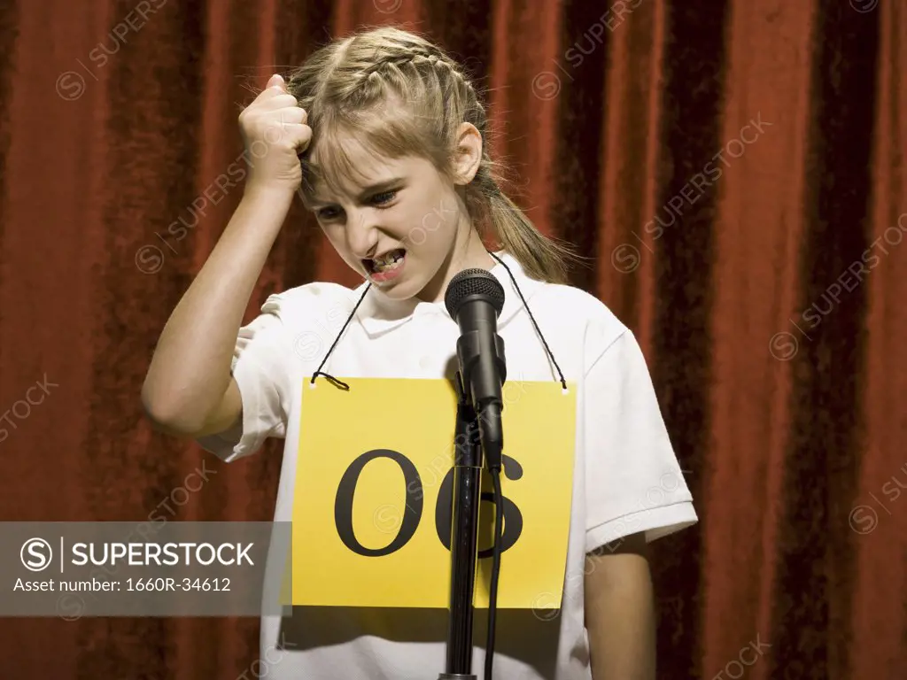 Girl contestant standing at microphone thinking