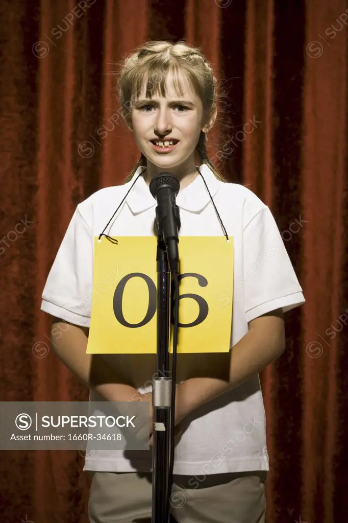 Girl contestant standing at microphone thinking