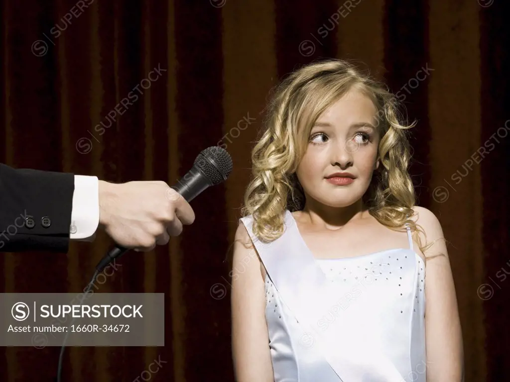 Girl beauty pageant contestant with microphone looking nervous
