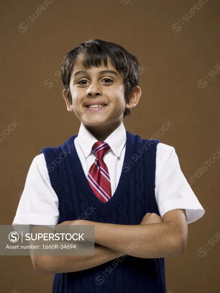 Boy standing with arms crossed smiling