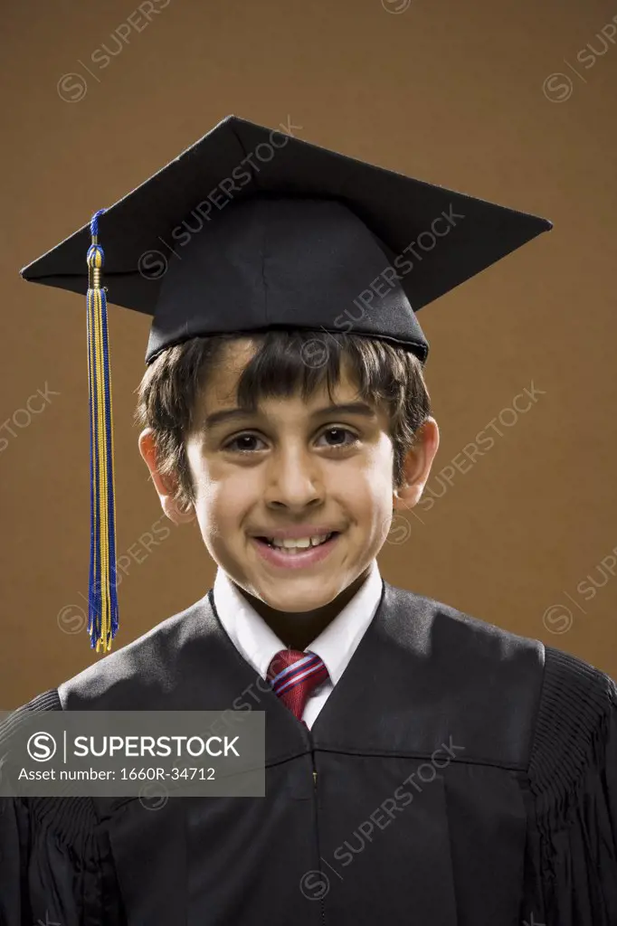 Boy graduate with mortar board smiling with arms crossed