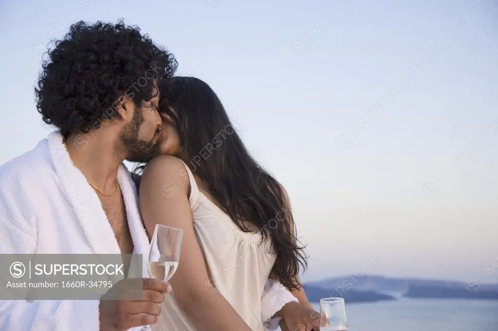 Couple kissing outdoors with champagne flutes