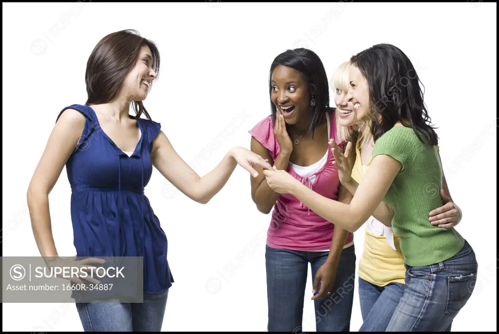 Three women looking at other woman's engagement ring smiling
