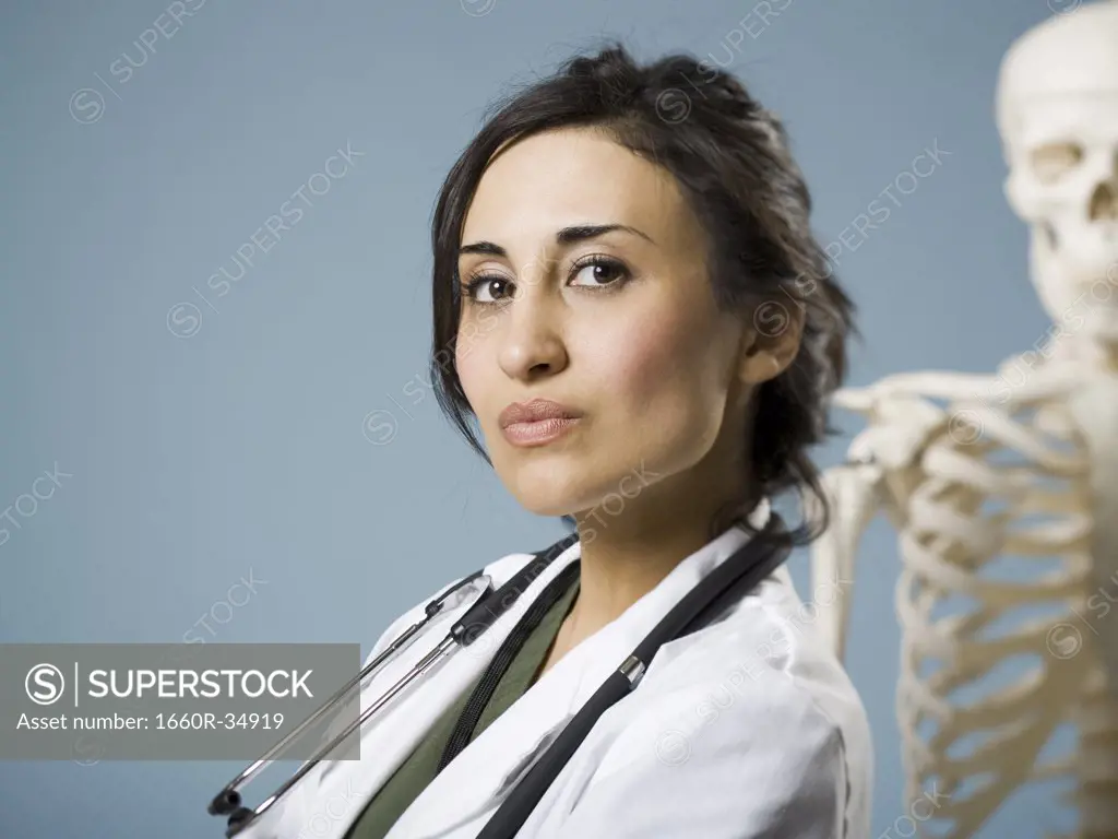 Female doctor smiling with skeleton in background