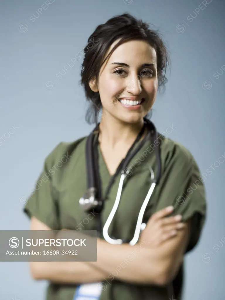 Woman in scrubs with arms crossed smiling