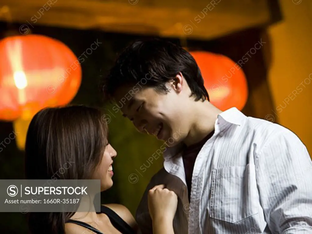 Couple embracing outdoors at night smiling