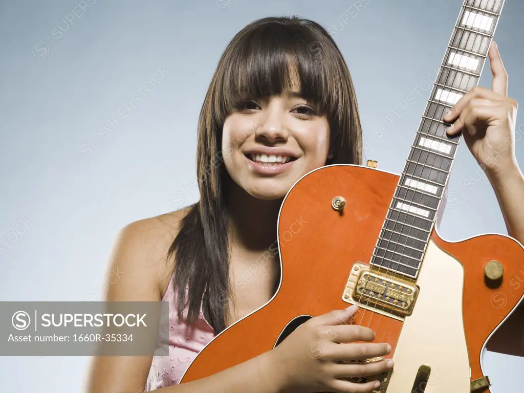 Woman playing guitar smiling