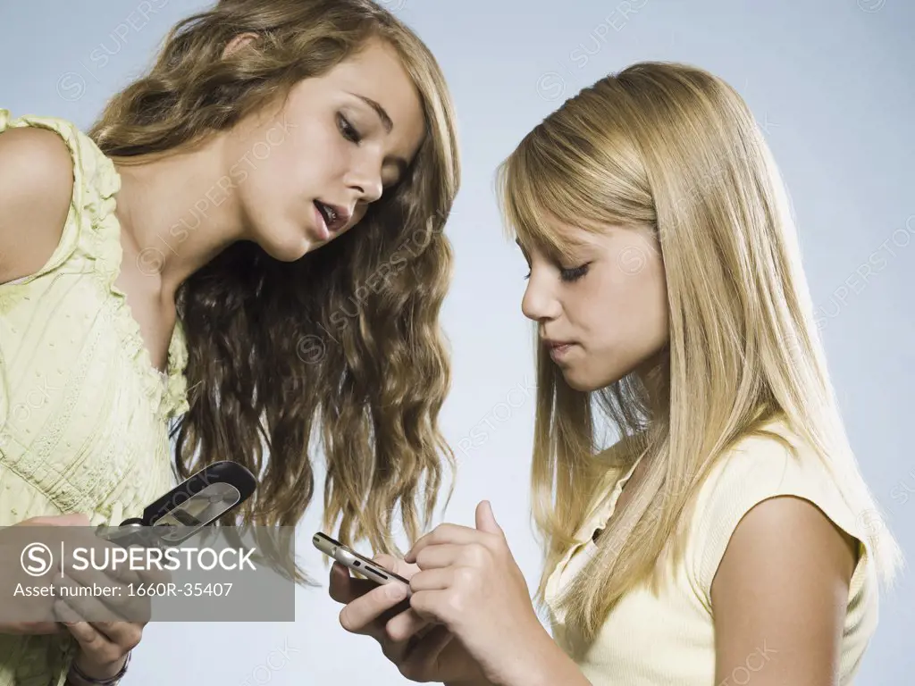 Two girls with cell phones smiling