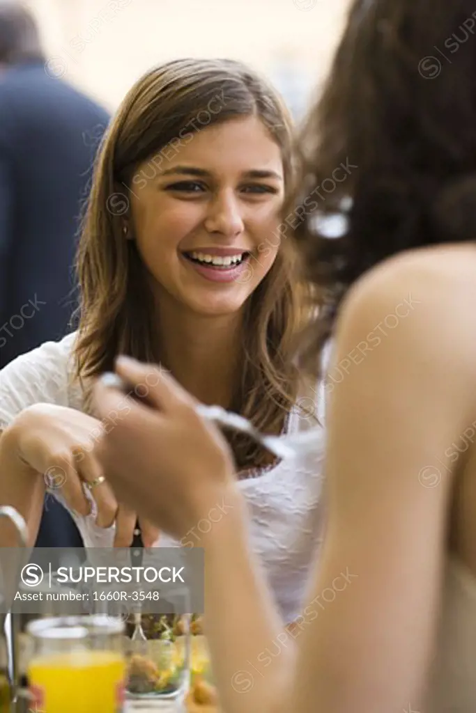 Two teenage girls having a meal in a restaurant