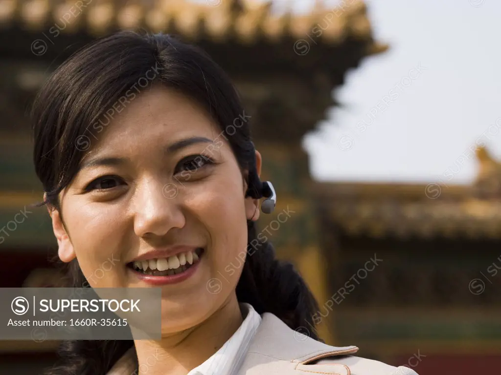 Businesswoman smiling outdoors with headset