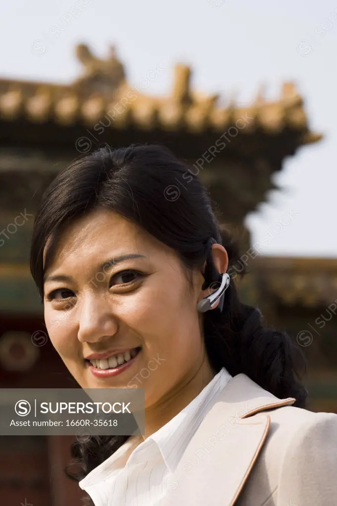 Businesswoman smiling outdoors with headset
