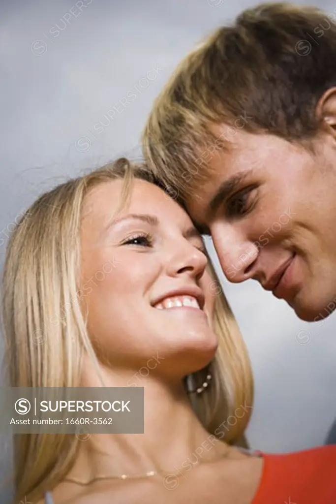 Close-up of a teenage couple smiling at each other