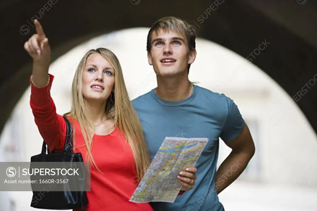 Teenage girl  holding a map and pointing