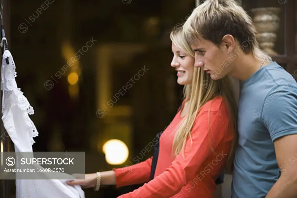 Portrait of a teenage couple looking at a dress