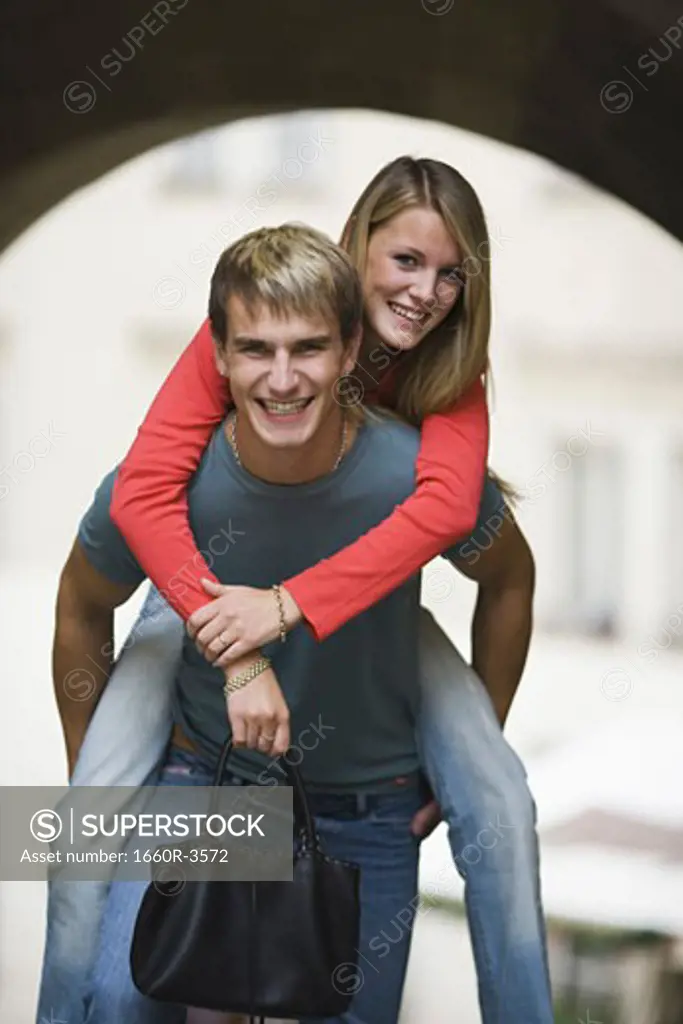 Portrait of a teenage boy giving a piggyback ride to a teenage girl