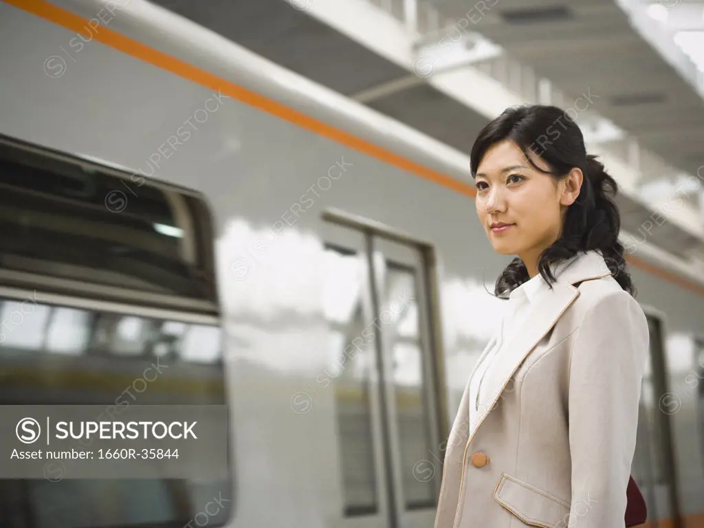Businesswoman on subway platform smiling