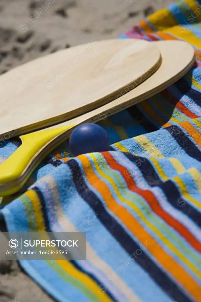 Close-up of paddleball rackets and ball on a towel