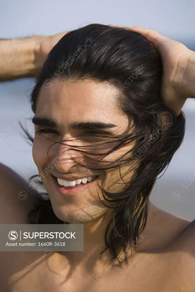 Close-up of a young man with his hands in his hair