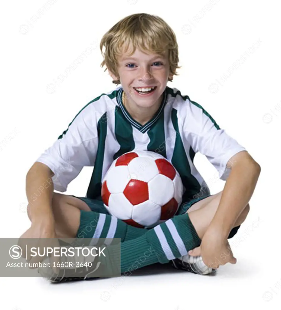 Portrait of a boy sitting with a soccer ball