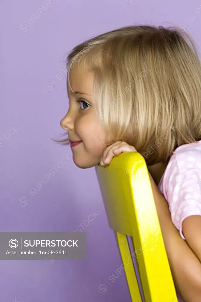Portrait of a girl resting her head on a chair