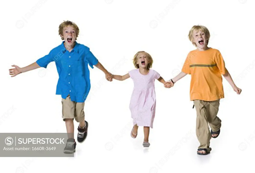 Portrait of two brothers running with their sister