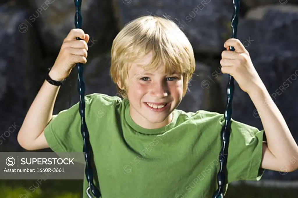 Portrait of a boy sitting on a swing