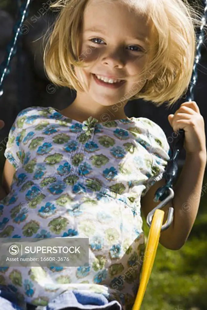 Portrait of a girl sitting on a swing