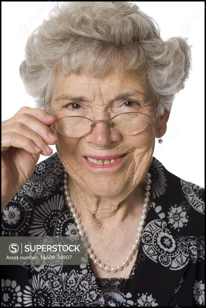 Senior woman with glasses looking sternly at camera.