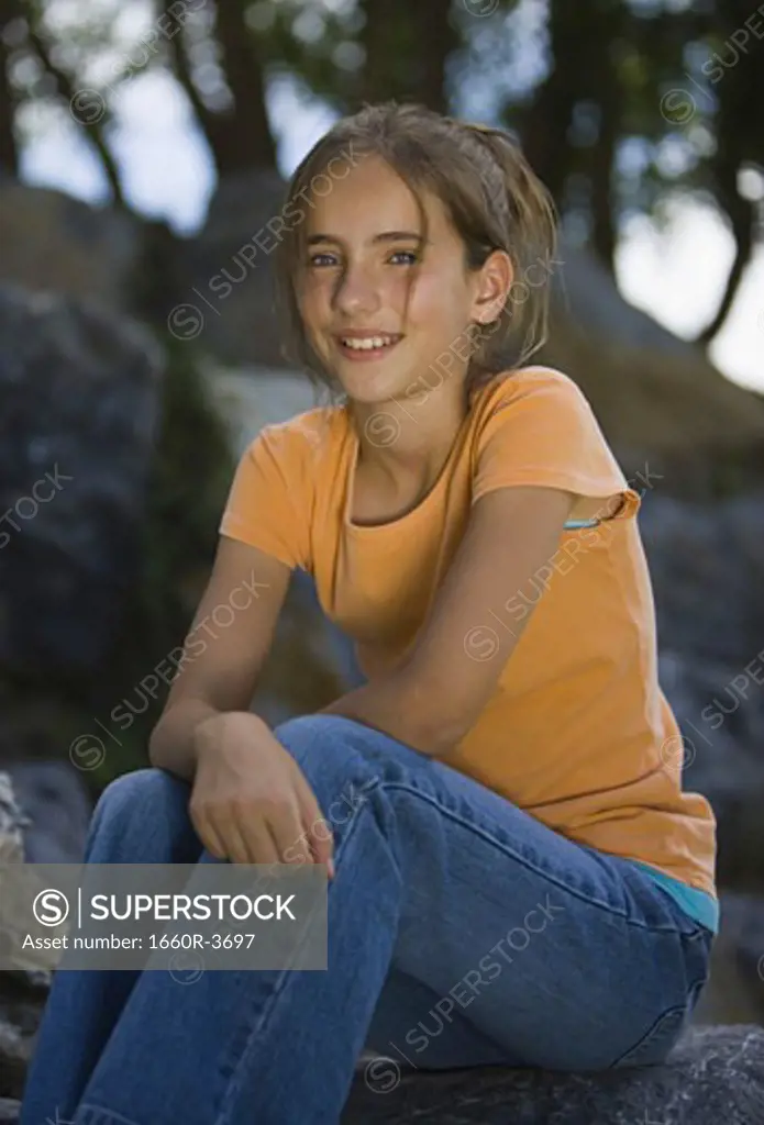 Portrait of a girl sitting on a rock