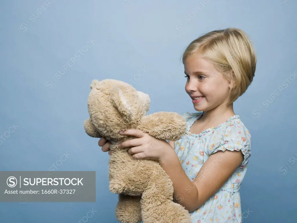girl hugging teddy bear.
