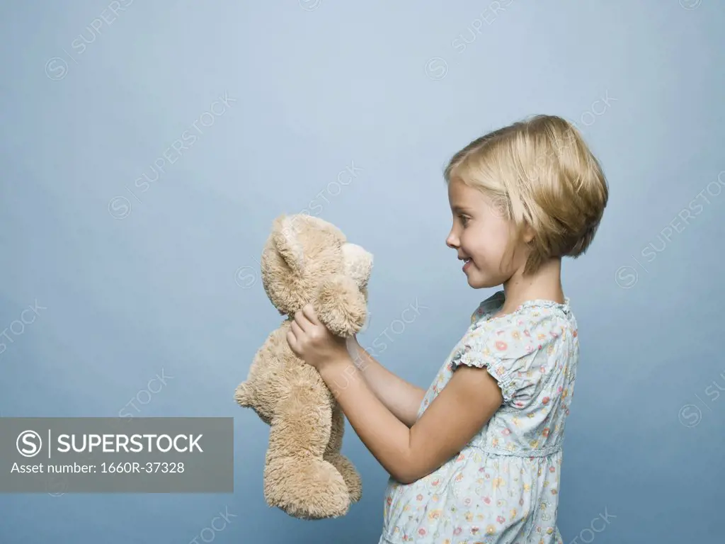 girl hugging teddy bear.