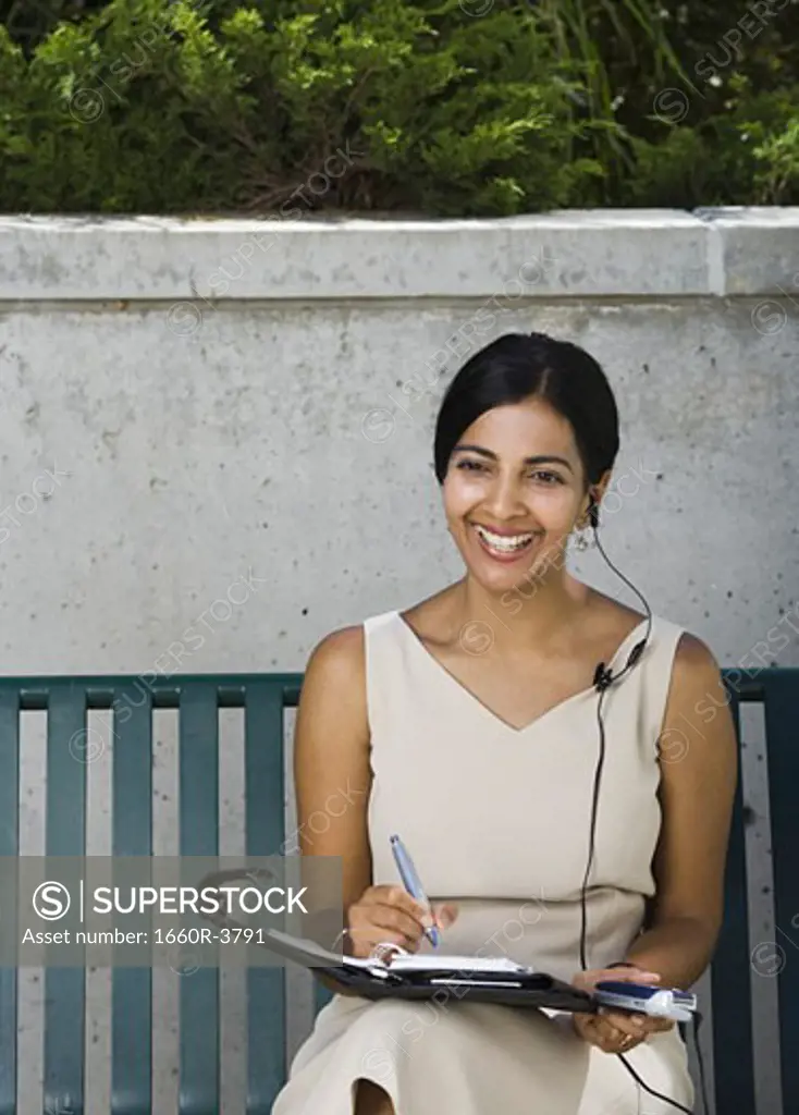Businesswoman sitting on a bench and smiling