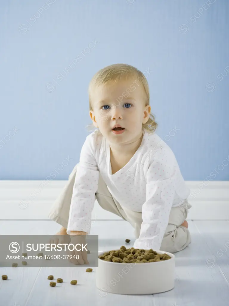 little girl with a bowl of dog food