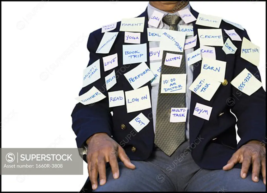 Mid section view of a businessman sitting with stickers on his suit