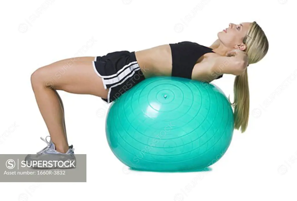 Profile of a young woman lying on a fitness ball
