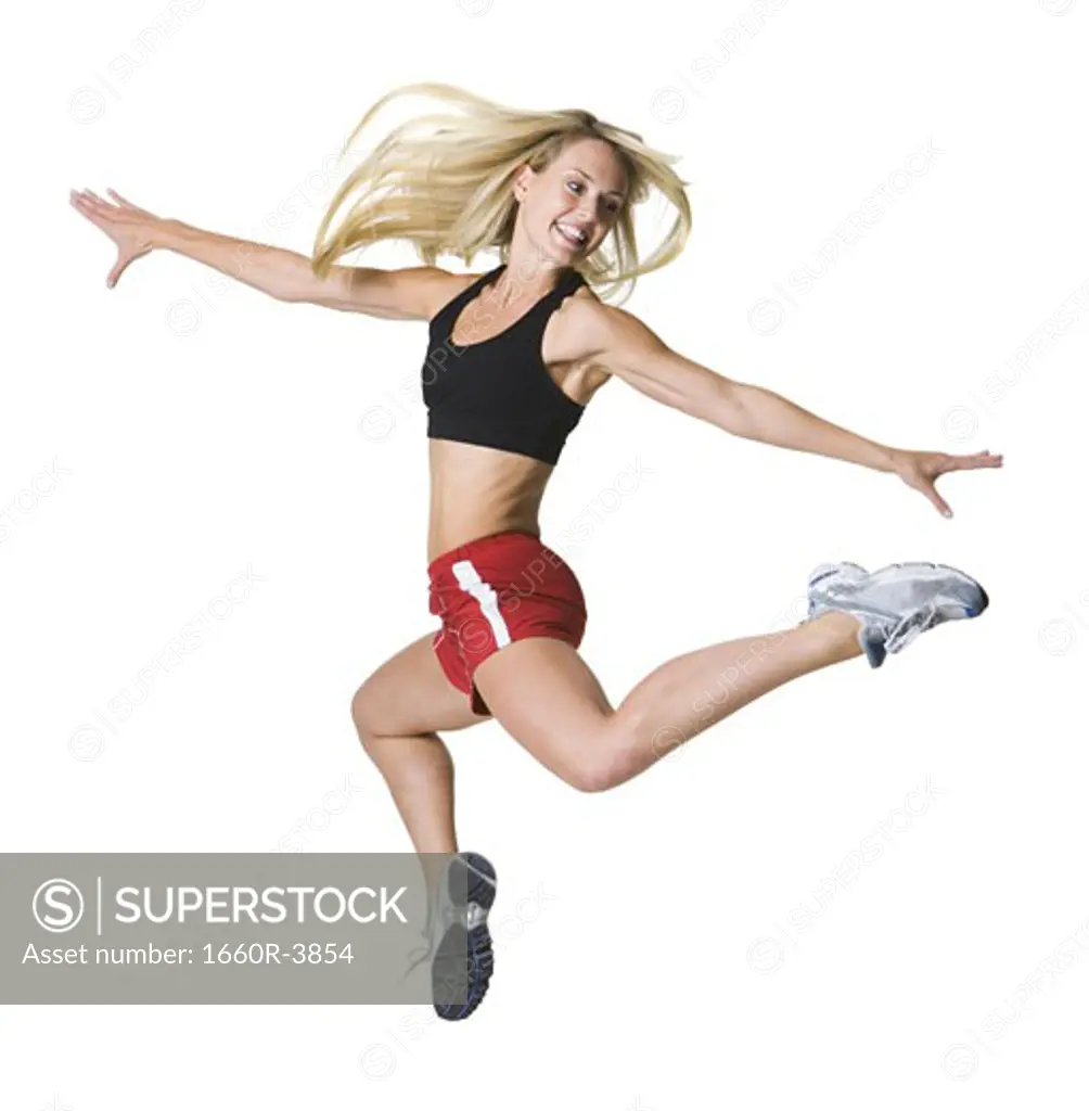Young woman jumping with her arms outstretched