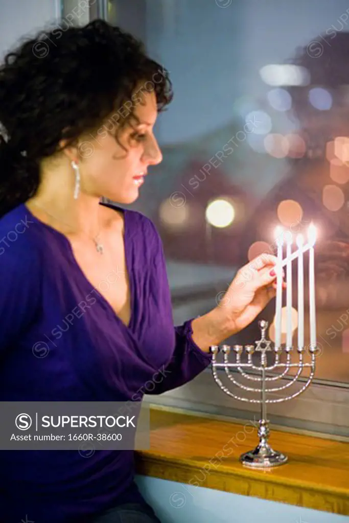 Woman lighting a menorah