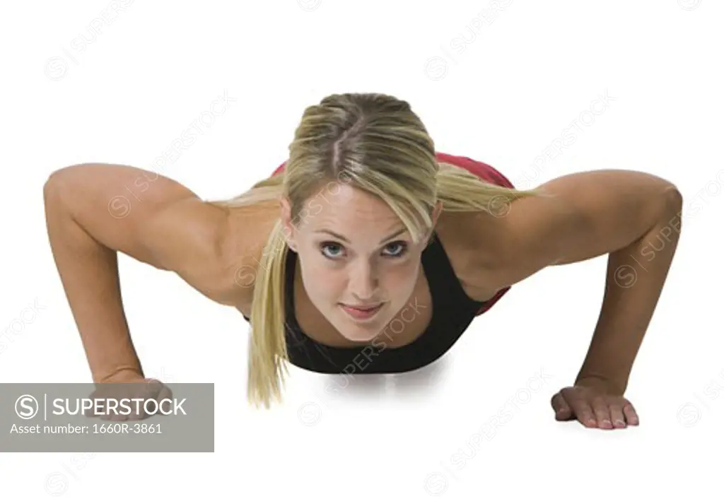 Portrait of a young woman doing push-ups
